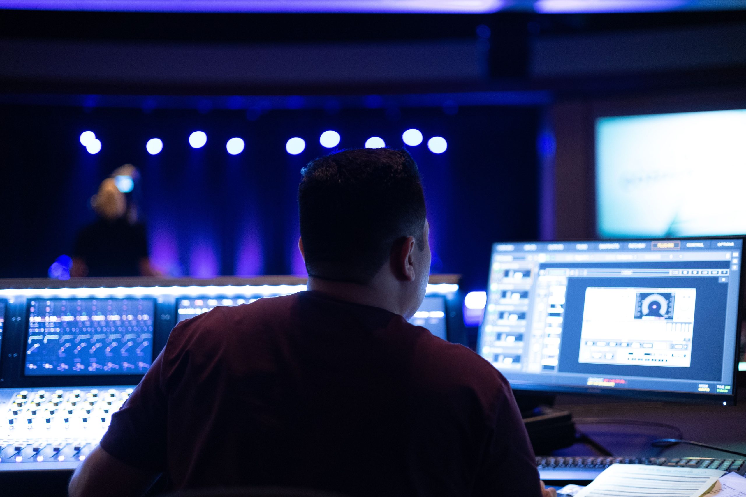 Audio engineer working with sound equipment and mixing console in a studio.